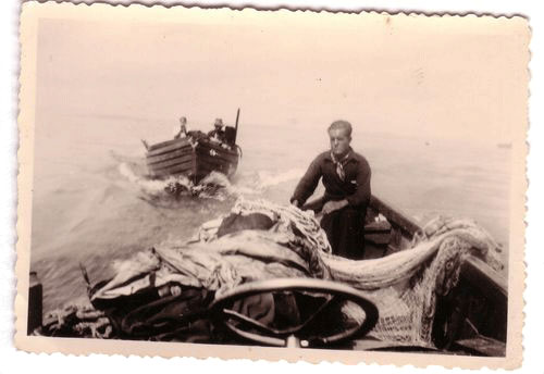 Ein sehr altes, an den Seiten ausgefranztes Bild. Ein Mann sitzt in einem Boot, vermutlich auf dem Bodensee, hinter ihm fährt ein weiteres Boot, in dem 2 Personen zu erkennen sind.