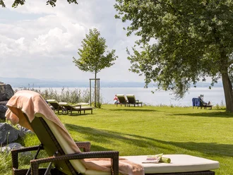 Liegewiese mit Sonnenliegen und Blick auf den Bodensee beim Hotel Schwedi – entspannen in idyllischer Natur direkt am Wasser.