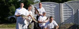 Küchenteam des Hotel Schwedi im Freien mit frisch gefangenem Fisch – regionale Kulinarik und handwerkliche Qualität im Fokus.